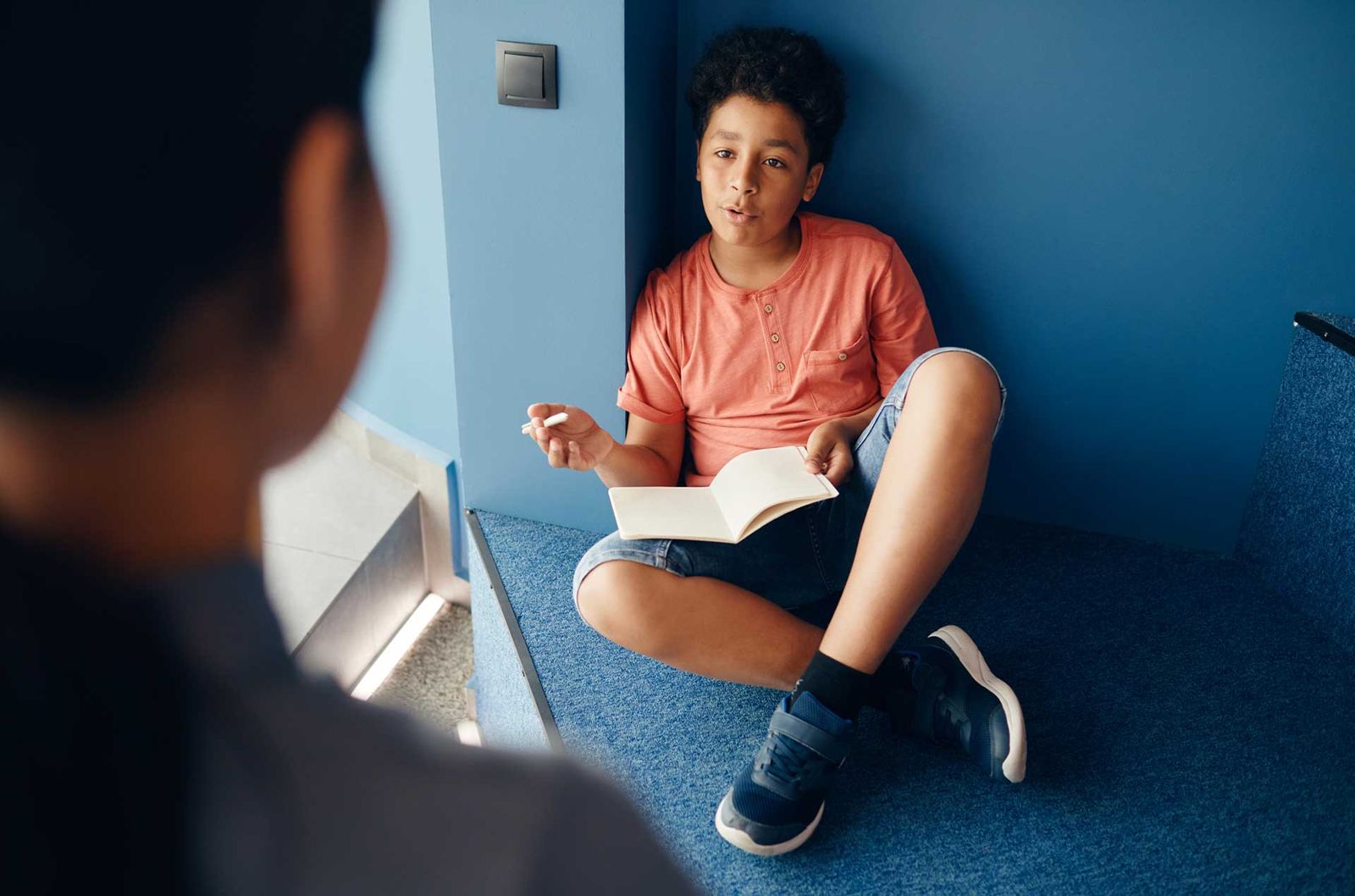 Begeleider en middelbare scholier in gesprek tijdens huiswerkbegeleiding in Den Haag